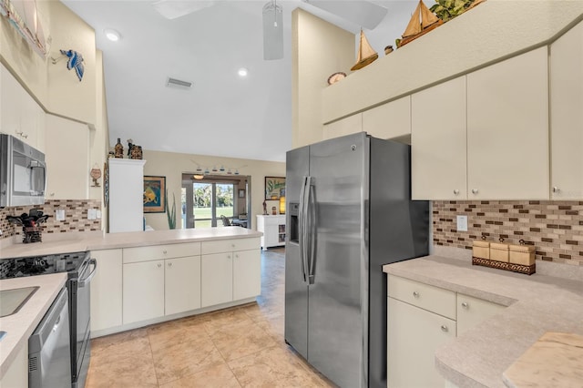 kitchen featuring appliances with stainless steel finishes, high vaulted ceiling, tasteful backsplash, light tile patterned floors, and kitchen peninsula