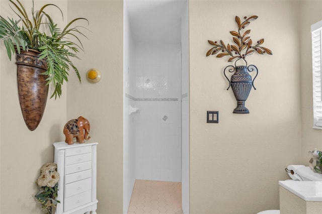 bathroom featuring toilet and tiled shower