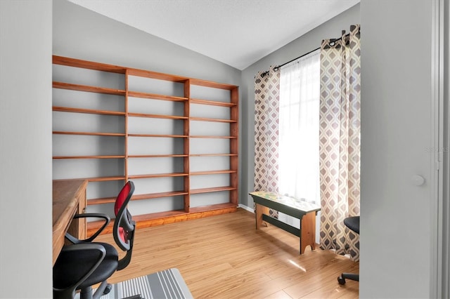 home office featuring lofted ceiling and wood finished floors