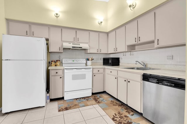 kitchen featuring light countertops, white appliances, a sink, and under cabinet range hood