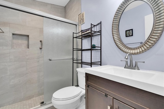 bathroom with toilet, a stall shower, and vanity