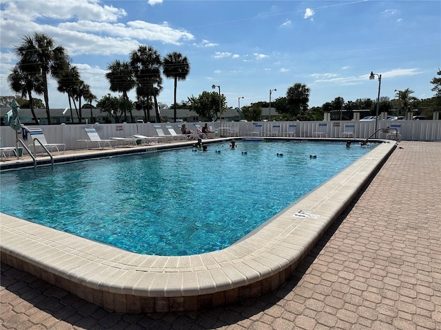 community pool featuring fence and a patio