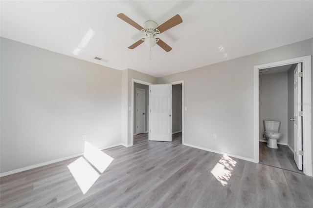 unfurnished bedroom featuring ensuite bathroom, ceiling fan, and light hardwood / wood-style flooring