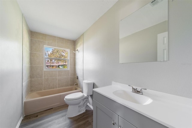 full bathroom with vanity, wood-type flooring, toilet, and tiled shower / bath