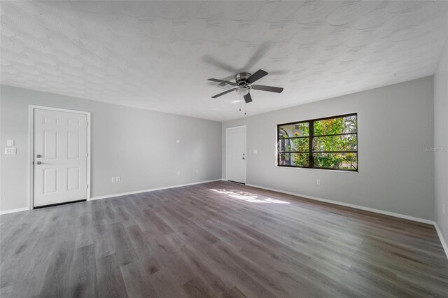 empty room featuring ceiling fan, hardwood / wood-style floors, and a textured ceiling