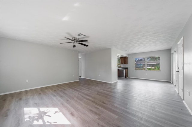 unfurnished living room with hardwood / wood-style flooring, ceiling fan, and a textured ceiling