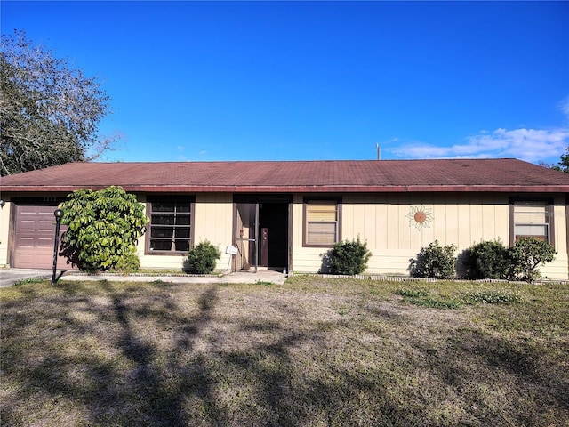 ranch-style home featuring a garage and a front lawn