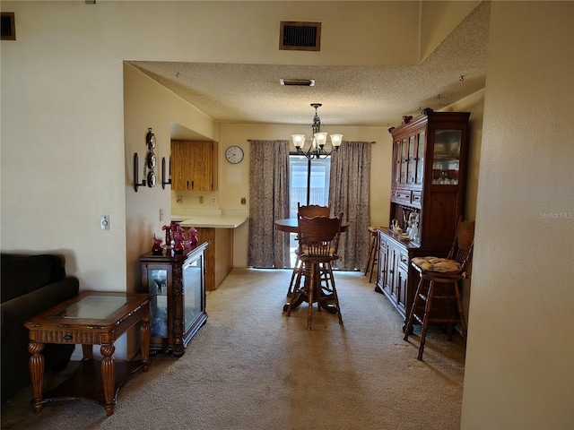 carpeted dining area featuring a textured ceiling and a notable chandelier