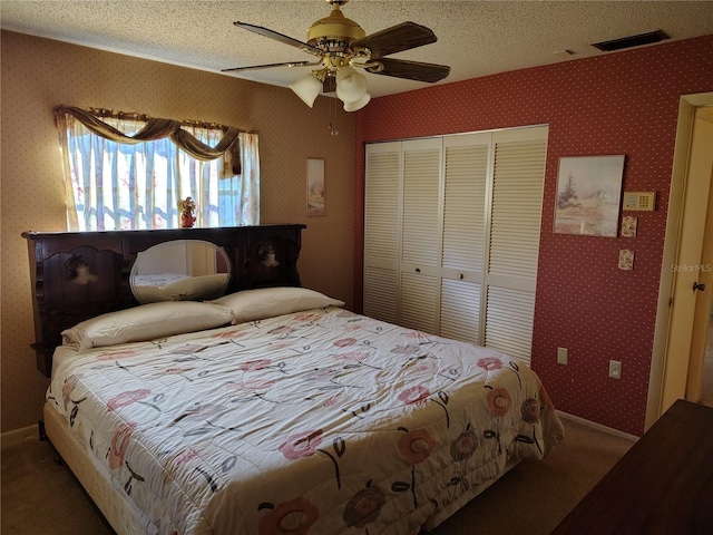 carpeted bedroom featuring ceiling fan, a closet, and a textured ceiling