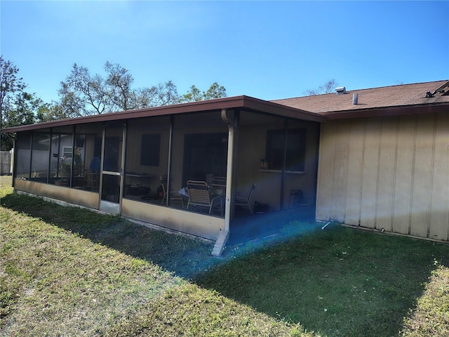 rear view of property with a yard and a sunroom