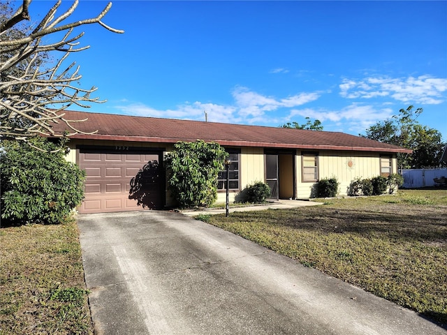 single story home featuring a garage and a front lawn