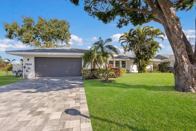 ranch-style home featuring a garage and a front lawn