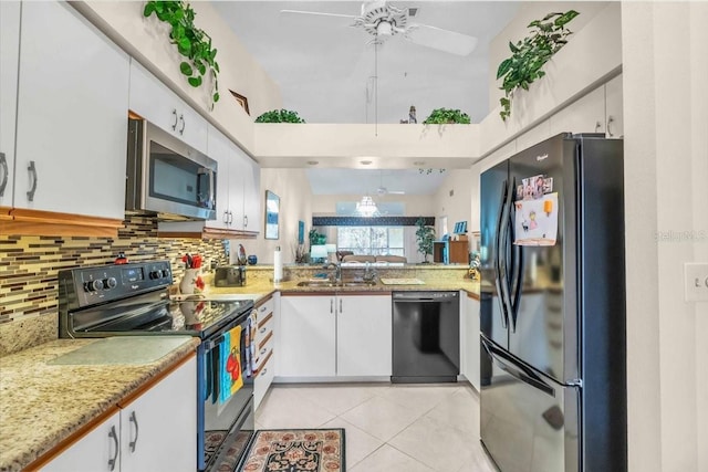 kitchen featuring tasteful backsplash, light tile patterned floors, white cabinets, and black appliances