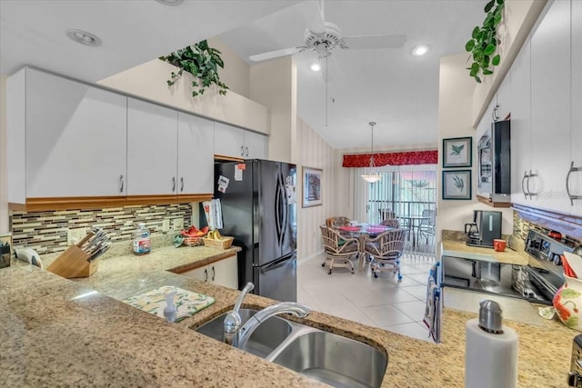 kitchen with black refrigerator, sink, white cabinetry, and electric range