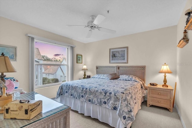 bedroom with ceiling fan and light carpet