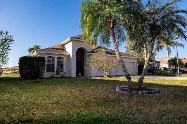 mediterranean / spanish house with a garage and a front yard