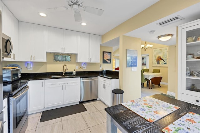 kitchen with stainless steel appliances, white cabinetry, and sink