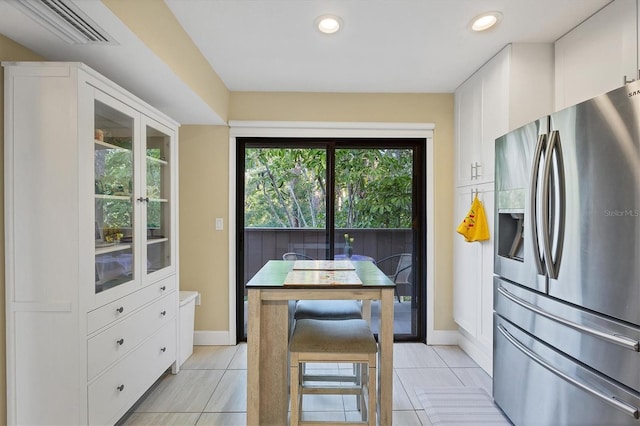 kitchen with white cabinetry, light tile patterned floors, and stainless steel fridge with ice dispenser