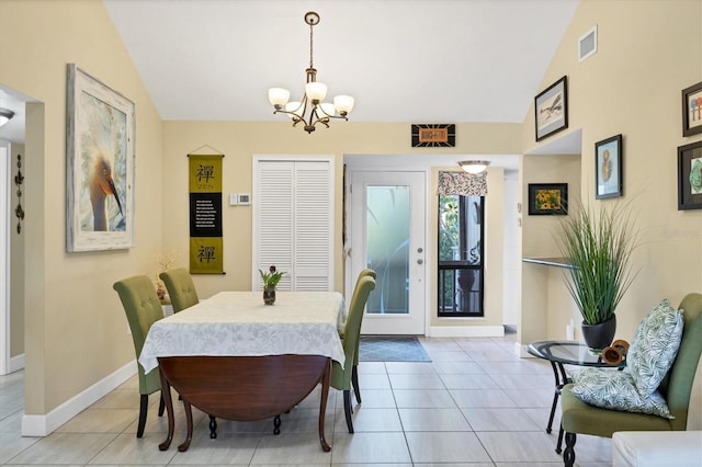 dining space with lofted ceiling, a chandelier, and light tile patterned floors