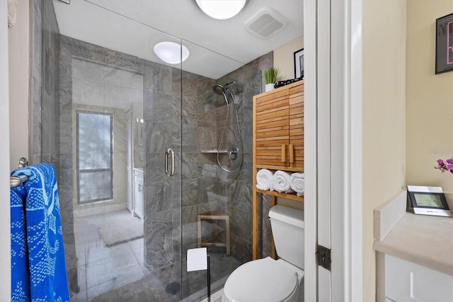 bathroom with an enclosed shower and toilet