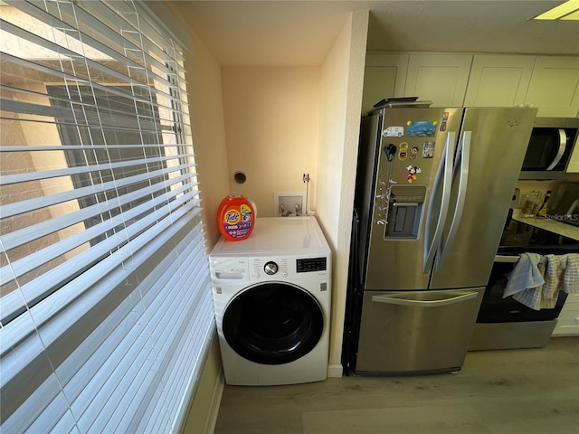 washroom featuring washer / clothes dryer and light wood-type flooring