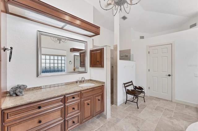 bathroom with baseboards, visible vents, lofted ceiling, walk in shower, and vanity