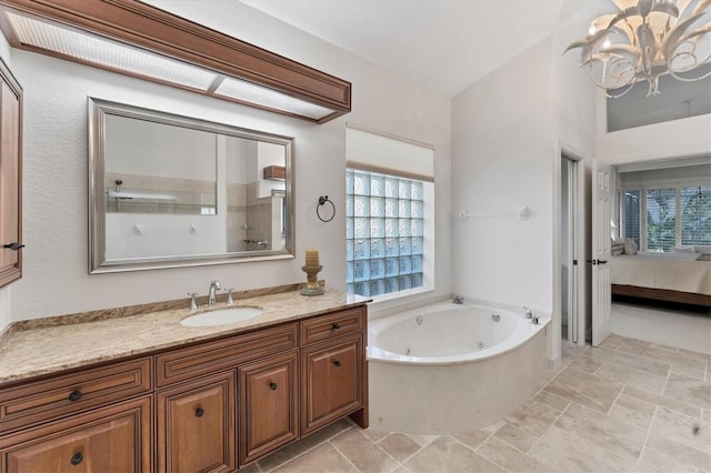 bathroom featuring a whirlpool tub, a notable chandelier, connected bathroom, and vanity