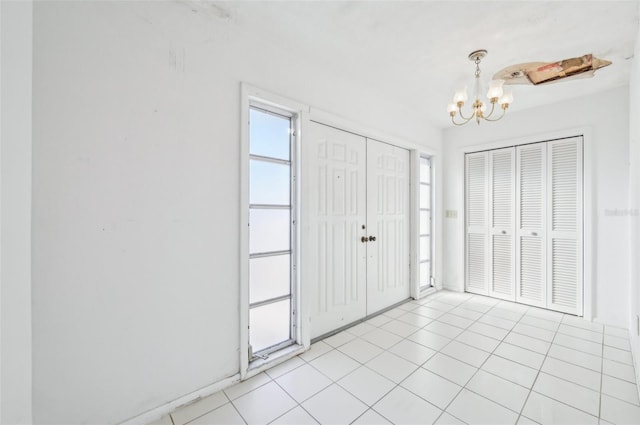 foyer entrance featuring an inviting chandelier and light tile patterned flooring