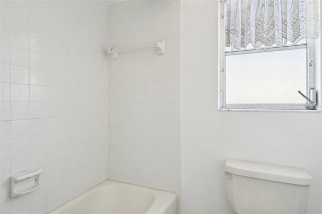 bathroom featuring a tub to relax in and toilet