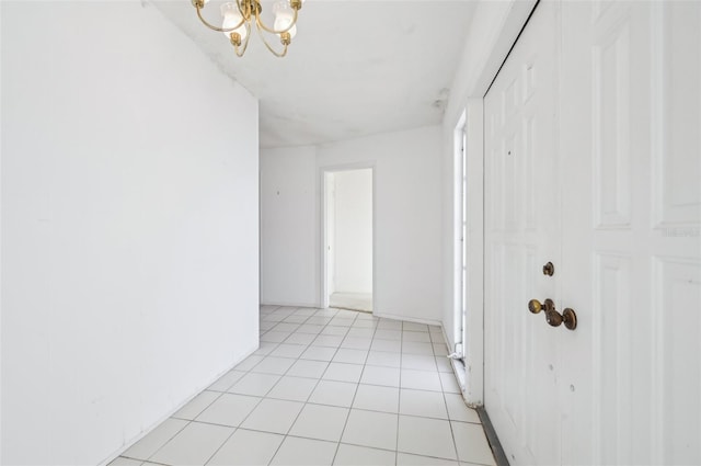 hallway featuring a chandelier and light tile patterned floors