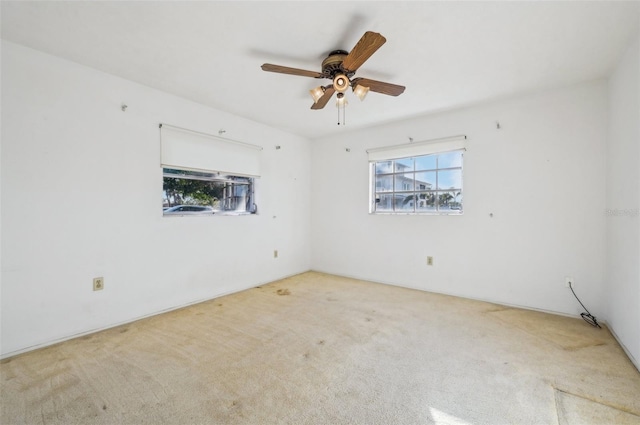 carpeted spare room featuring ceiling fan