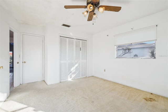 unfurnished bedroom with ceiling fan, a closet, and light carpet