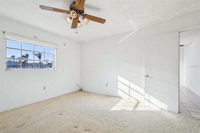 carpeted spare room with ceiling fan