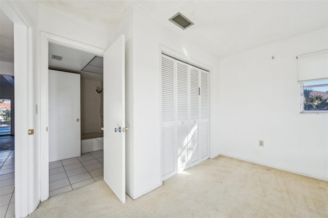 unfurnished bedroom with multiple windows, light colored carpet, and a closet