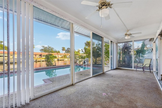 unfurnished sunroom with a water view and ceiling fan