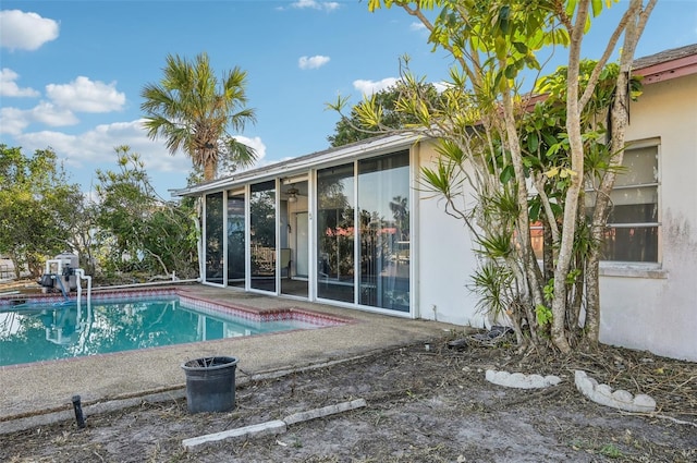 view of pool with a sunroom and a patio