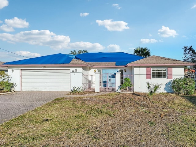 ranch-style house featuring a garage and a front lawn