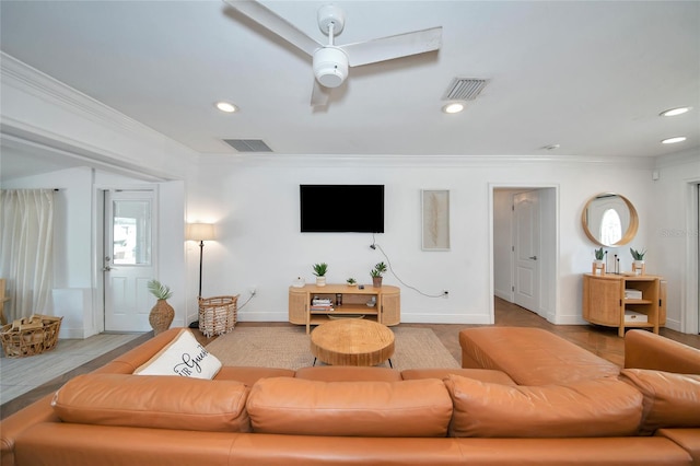 living room with hardwood / wood-style flooring, crown molding, and ceiling fan