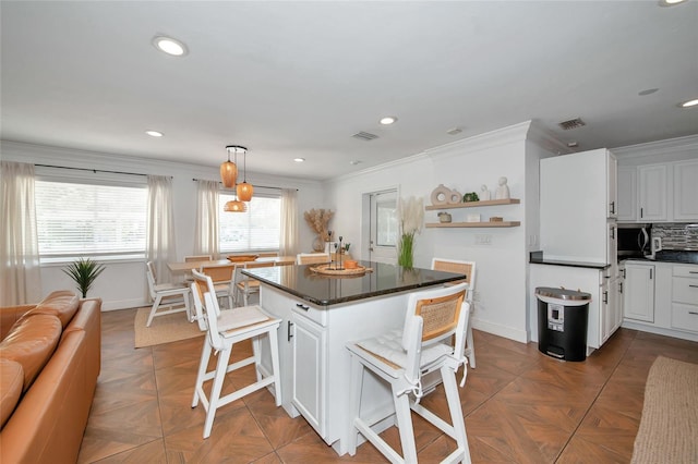 kitchen with white cabinetry, dark parquet flooring, and a breakfast bar