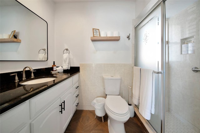 bathroom with tile walls, vanity, parquet flooring, a shower with shower door, and toilet