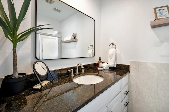 bathroom with vanity and tile walls