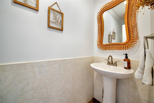 bathroom featuring sink and tile walls