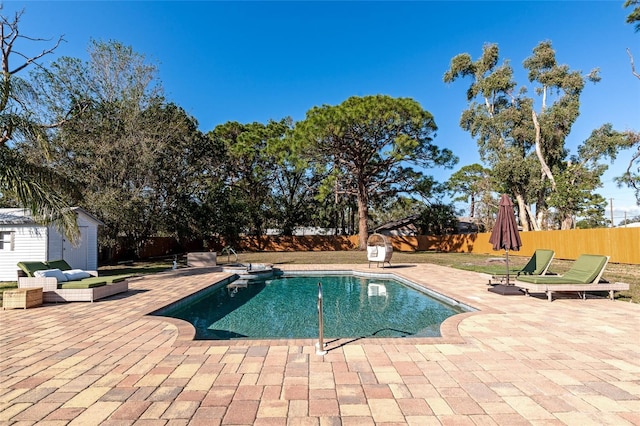 view of pool featuring a patio area and a storage unit