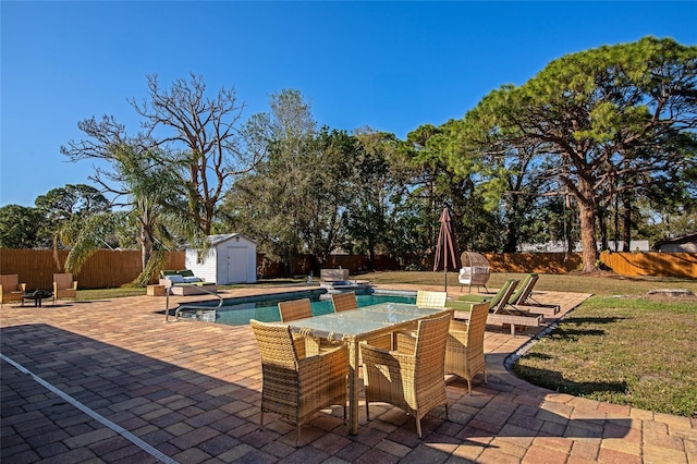 view of swimming pool featuring a storage shed and a patio