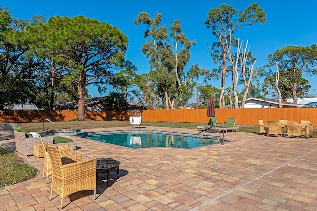 view of swimming pool featuring a patio and an outdoor fire pit