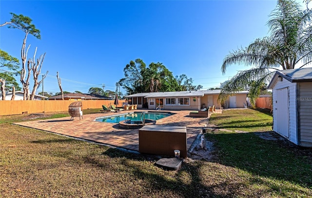 view of pool with a storage shed, a lawn, and a patio area