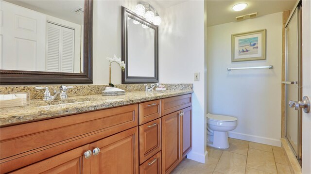 bathroom featuring double vanity, visible vents, toilet, a sink, and tile patterned floors