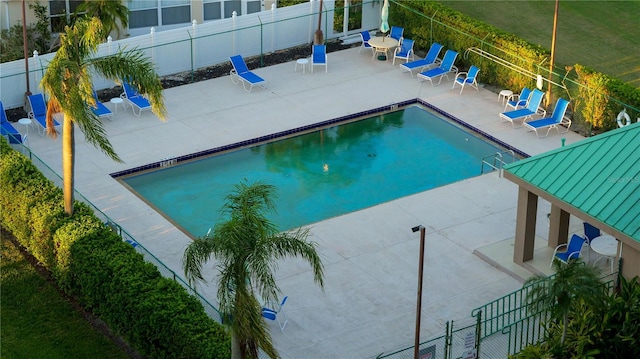 community pool featuring fence and a patio