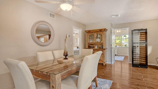 dining space featuring wine cooler, ceiling fan, and hardwood / wood-style floors