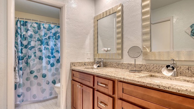 bathroom with walk in shower, tile patterned floors, vanity, and toilet